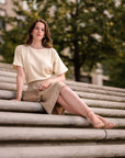 Model sitzt auf einer Treppe und trägt einen Strickrock in der Länge midi von der Marke Bellasor.