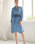 Unser Model trägt ein Blusenkleid in Kombination mit einem Stoffgürtel zum binden in der Farbe blau.
