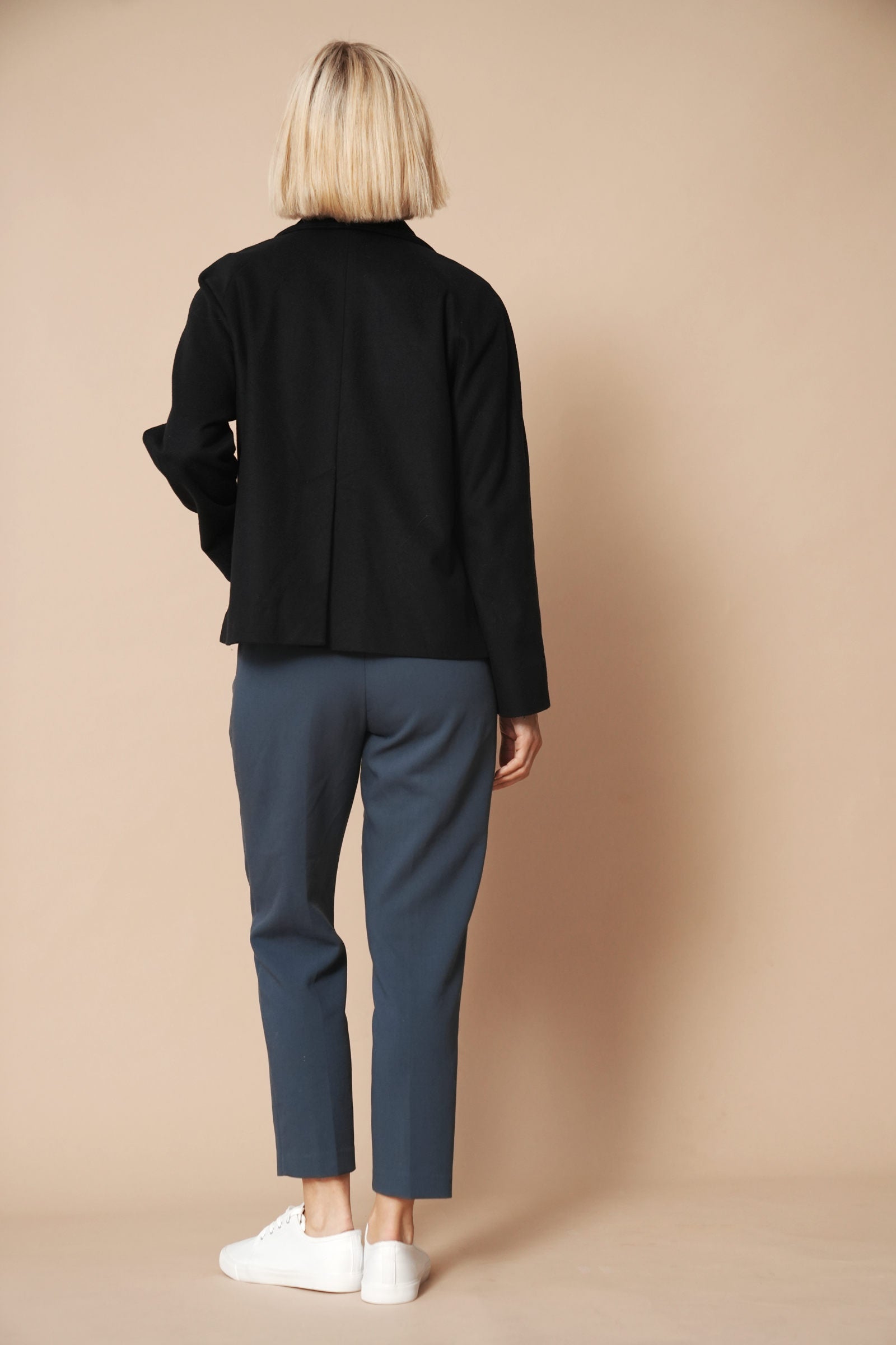 Model trägt eine Jacke aus Wolle und Kaschmir in der Farbe night blue. Gerader Schnit im Boxy-Fit Style. Sie zeigt die Ansicht vin hinten.