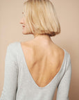 Rückenfreies Sommerkleid knielang in grau wird von einer Frau mit blonden Haaren getragen. Das Model zeigt die Rückansicht des Outfits.