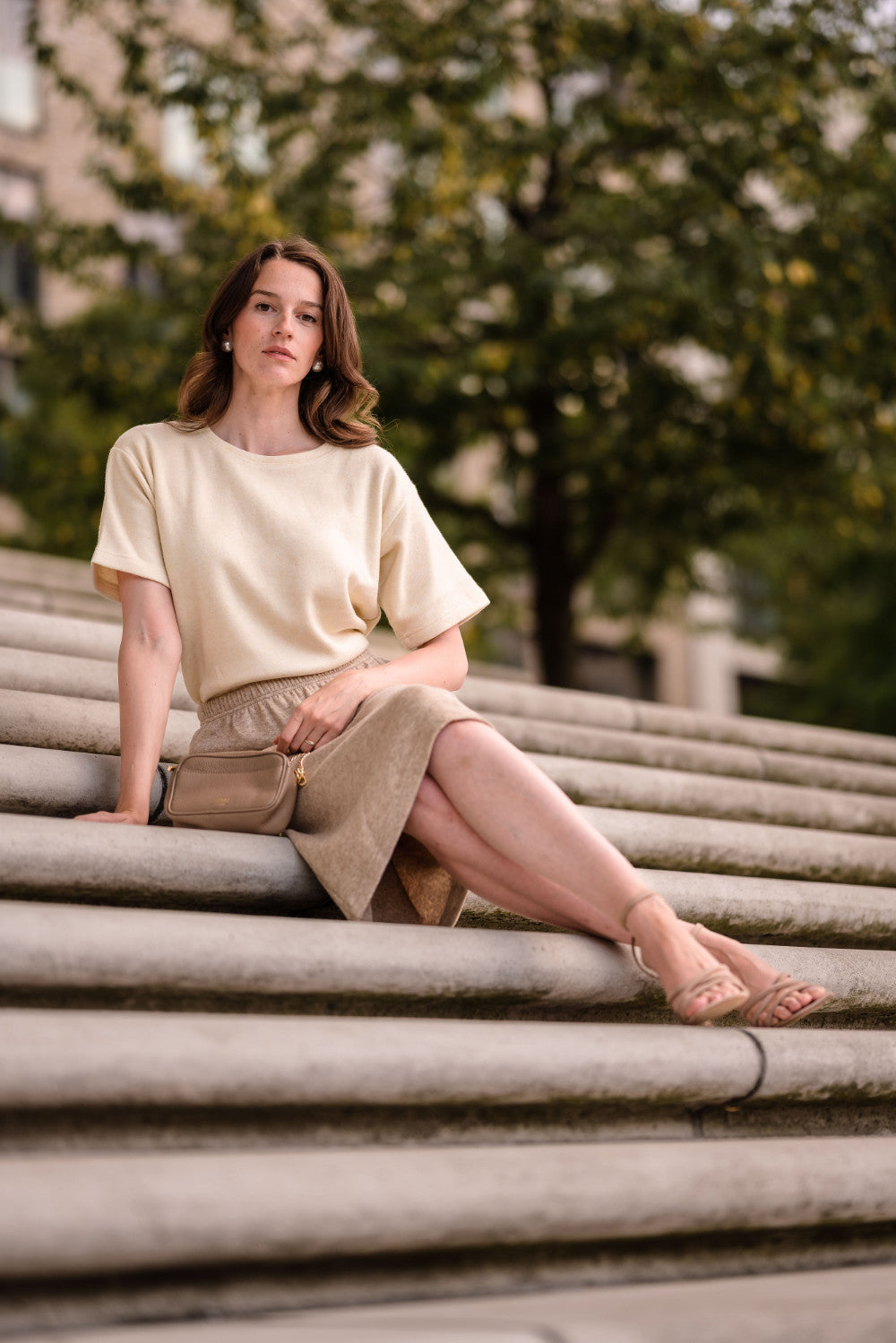 Model sitzt auf einer Treppe und trägt einen Strickrock in der Länge midi von der Marke Bellasor.