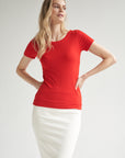 Rotes T-Shirt kombiniert mit einem weißen Bleistiftrock wird von einem blonden Model getragen.