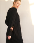 Unser Model trägt ein Strickkleid in schwarz von Bellasor. Sie ist seitlich von hinten zu sehen.