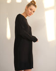 Unser Model trägt ein Strickkleid in schwarz von Bellasor. Sie ist von der Seite zu sehen.