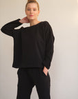 Model trägt einen sehr weichen Pullover in der Farbe schwarz.